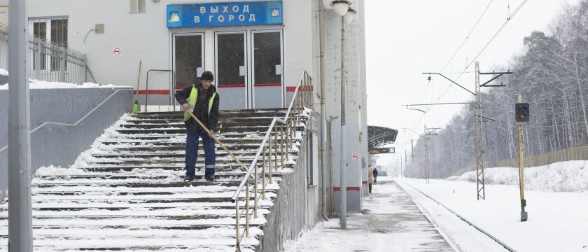 Дворник чистит ступеньки лестницы на ж/д станции Ивантеевка-2, Московская область