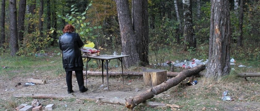 Женщина стоит возле столика в лесу, повсюду валяется мусор, Ивантеевка, Московская область