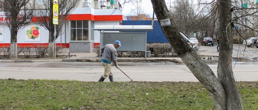 Работник убирает мусор с дороги, улица Советский проспект, город Ивантеевка, фотография середины апреля 2015 года