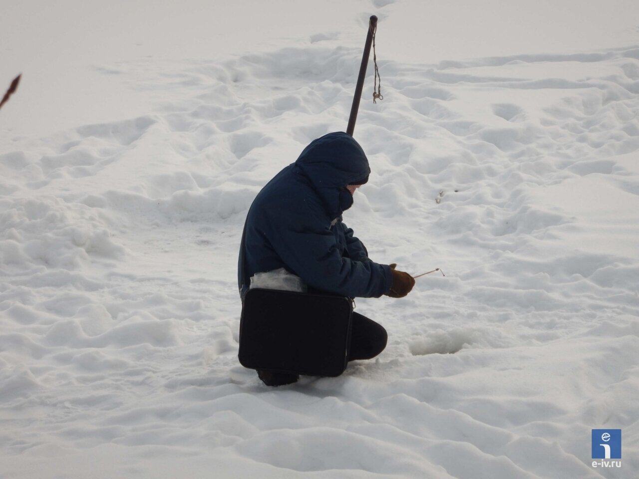 Мужчина ловит рыбу в реке Уча, зимняя рыбалка, Ивантеевка, Московская область