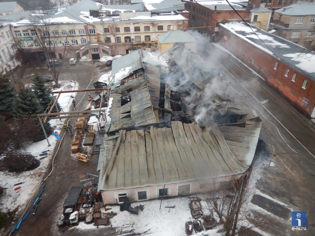 Вид сверху на пожар в одном из помещений фабрики имени Дзержинского, обрушилась крыша, из здания идет дым