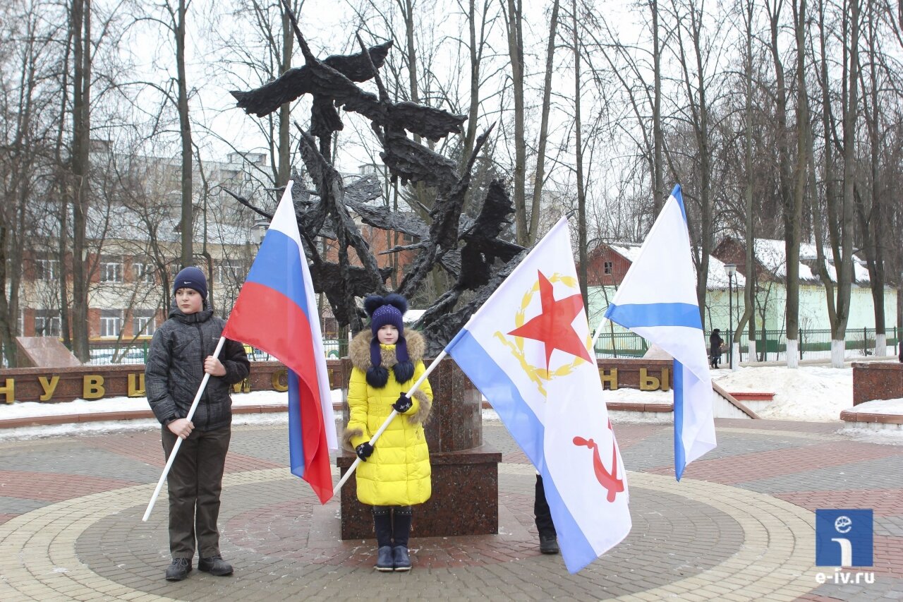 Молодые люди держат флаги около мемориала "Не вернувшимся с войны", Первомайская улица