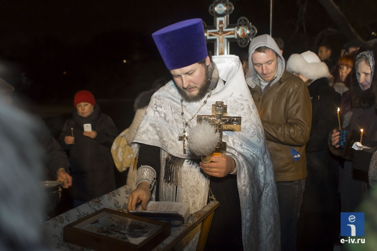Священник стоит над иконой и священной книгой, Крещение в Пушкине, Московская область