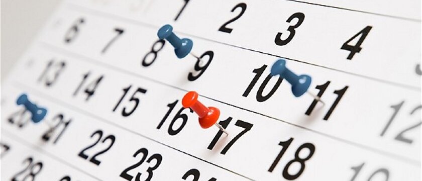 Календарь на месяц, несколько дней отмечены канцелярскими булавками