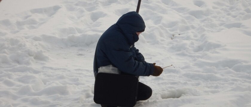 Мужчина ловит рыбу в реке Уча, зимняя рыбалка, Ивантеевка, Московская область