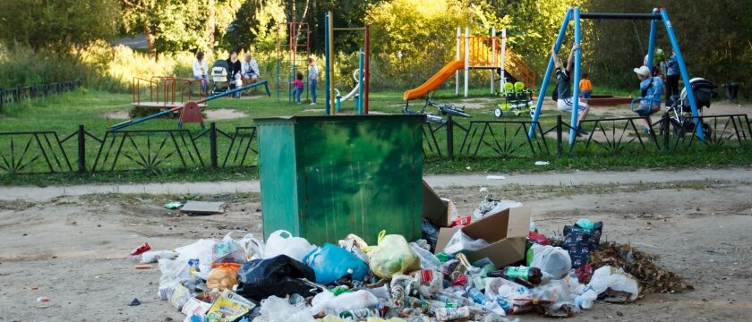 Много мусора вокруг контейнера, на заднем плане детская площадка, дети играют, родители общаются, Советский проспект, Ивантеевка, Московская область