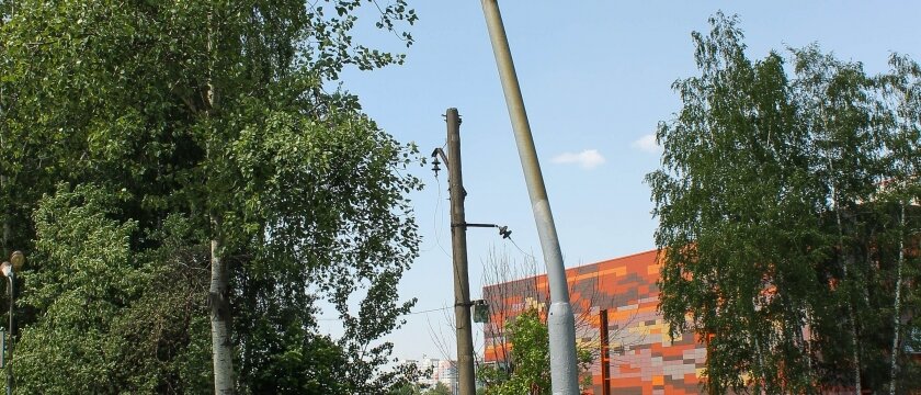 Платформа Ивантеевка-1, погнутый столб освещения вдоль ограждения, на заднем фоне парковка и ТЦ «Верный», фото от 27 мая 2015 года