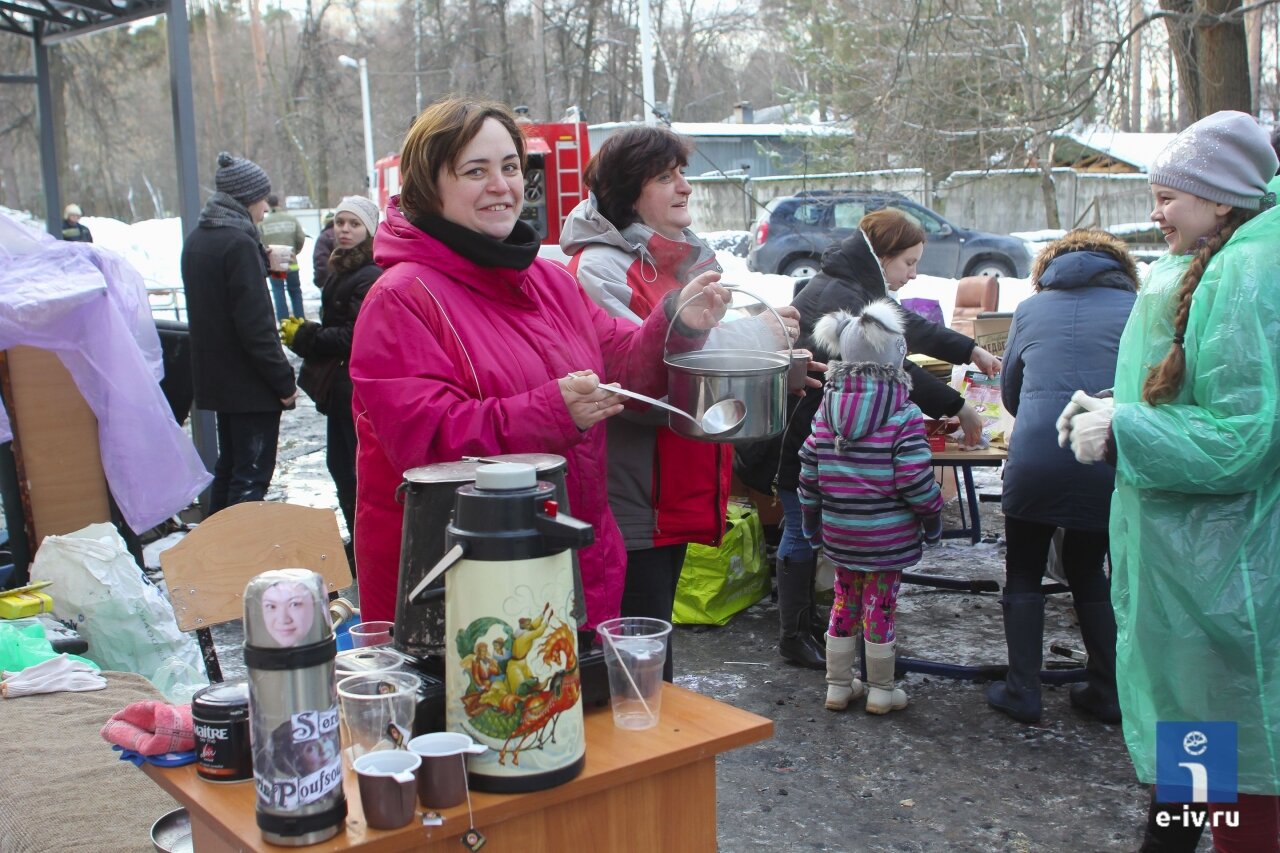 Волонтеры разливают горячий чай добровольцам, которые помогают разбирать вещи после пожара